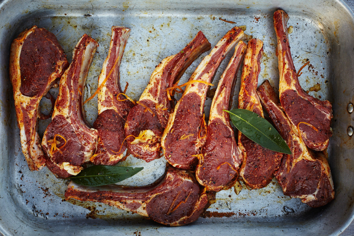 A baking tray filled with marinated lamb chops